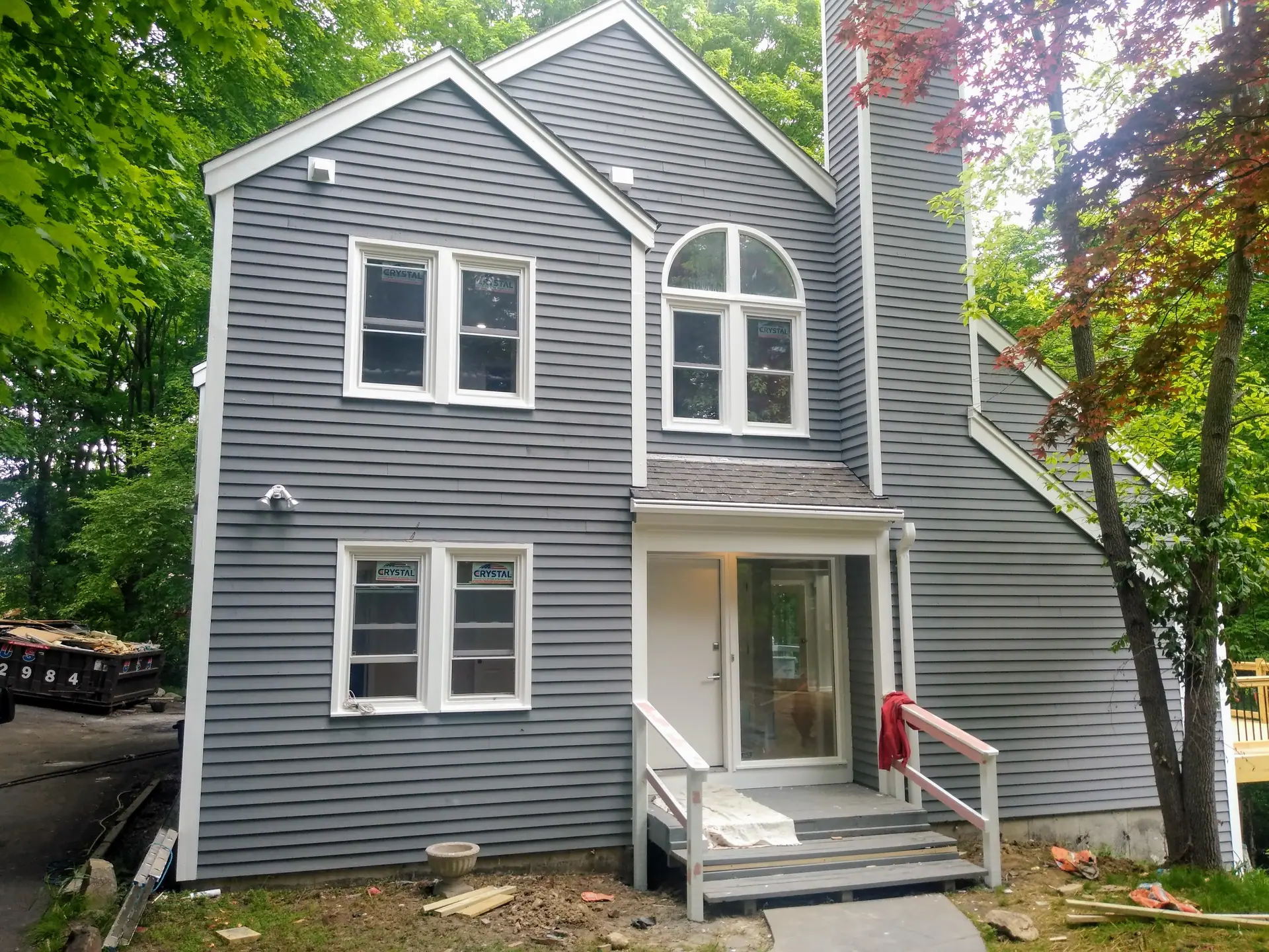Gray two-story home with new siding and a rebuilt entry