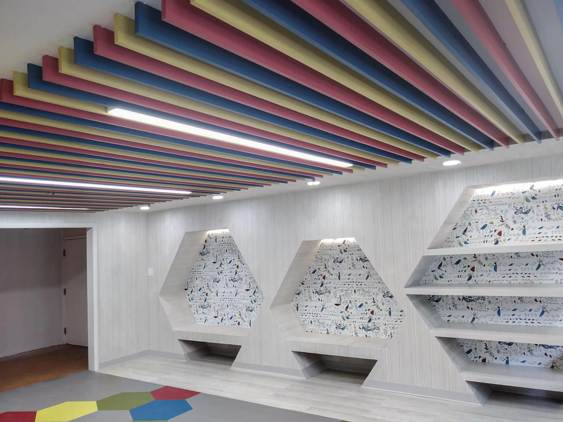 Painted slat ceiling in rainbow colors above the built-ins